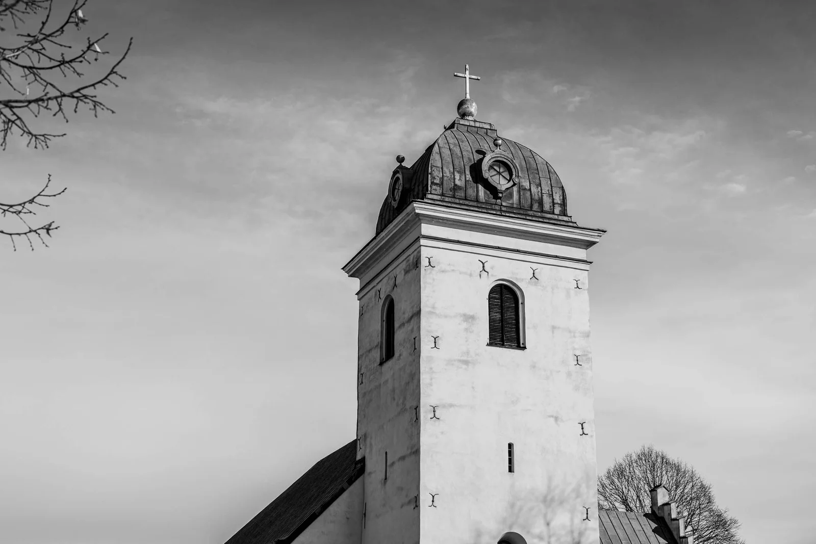 Svartvitt kyrktorn mot en ljus himmel